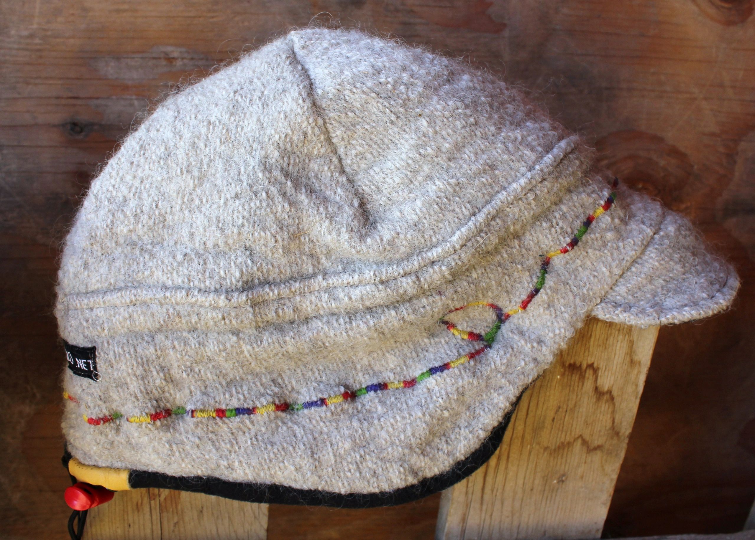 Wool hat on wooden stand with embroidered trim
